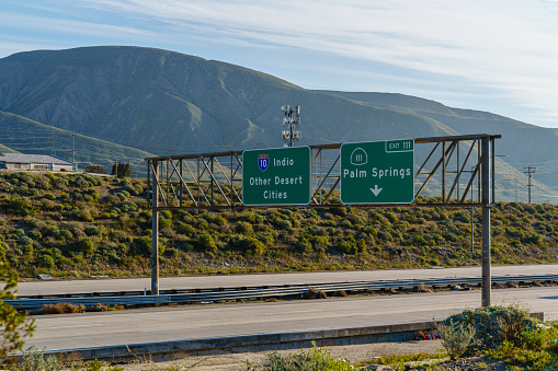 Green freeway signs on Interstate 10 I-10 for Other Desert Cities, Indio, and 111 Palm Springs in California.