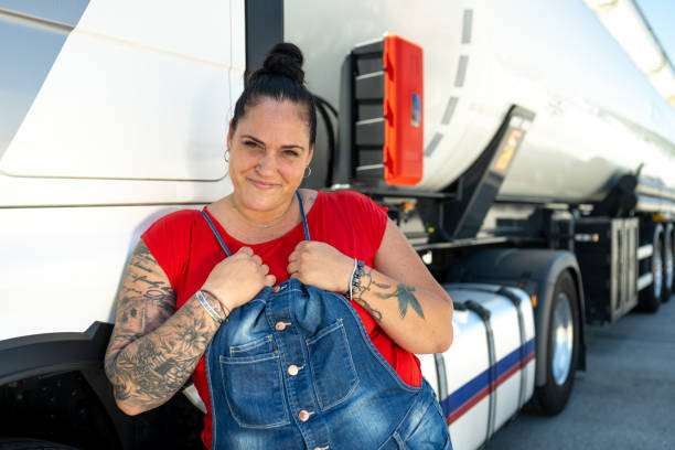 istock Smiling female cistern driver leaning against a cabin door 1549127747