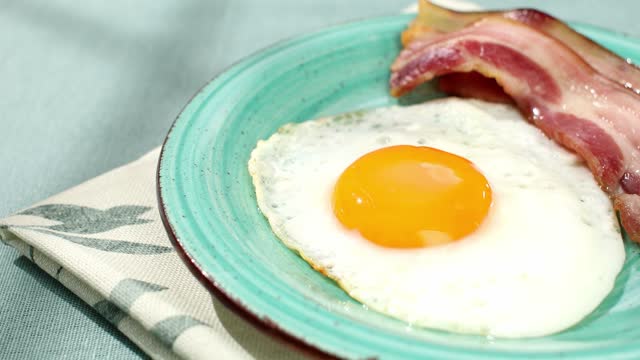 fried eggs with bacon on a plate. breakfast on the table. sunny morning. country style. organic food