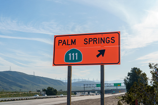 Orange road construction sign directing to Highway 111 leading to Palm Springs, California. Located on the 1-10 Interstate 10 freeway.