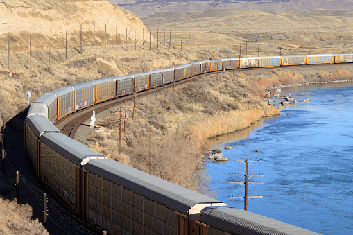 Freight train of car carriers rounding the bend on the Snake River near Glenns Ferry, Idaho.