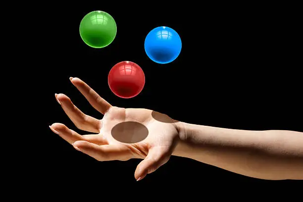 Photo of Multitasking;  Juggling Three Colorful Balls in One Hand