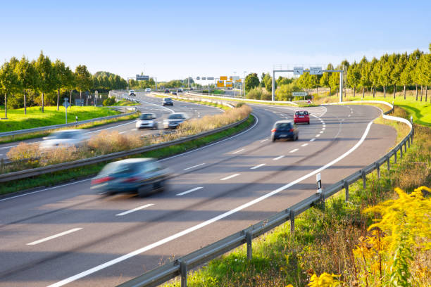 mehrspurige verkehr auf autobahn in sonnenuntergang mit motion blur - motorfahrzeug steuern stock-fotos und bilder