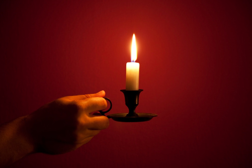 burning candle in a human hand 