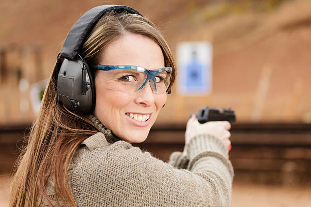 Woman Shooter at the Shooting Range A woman at the shooting range aiming a gun at the target. gun revolver stock pictures, royalty-free photos & images
