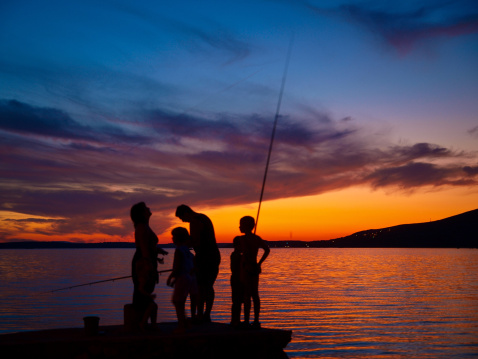 Family fishing at beautiful sunset.
