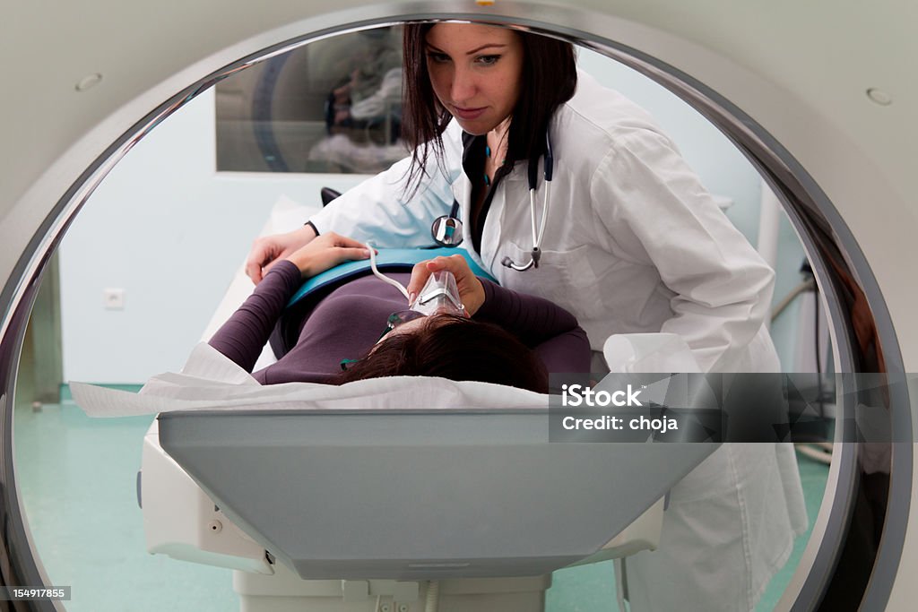 Młody lekarz i pacjent w Tomograf komputerowy - Zbiór zdjęć royalty-free (Fotografika)