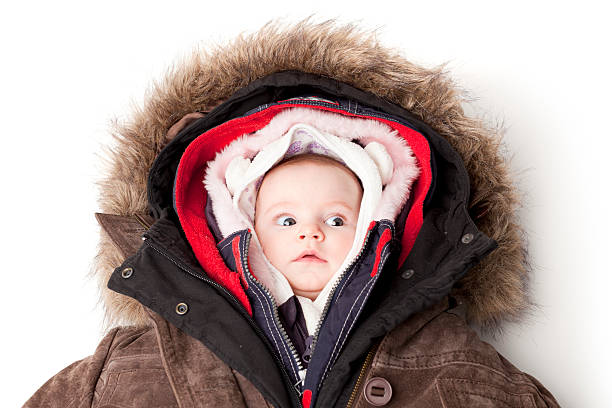 capucha bebé. niña en muchos invierno chaquetas. - abrigarse fotografías e imágenes de stock