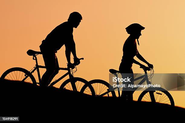 Ciclismo En La Puesta De Sol Foto de stock y más banco de imágenes de Actividad al aire libre - Actividad al aire libre, Actividades recreativas, Actividades y técnicas de relajación