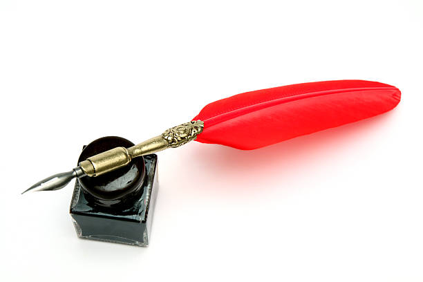 Red quill pen and black inkwell on a papyrus leaf