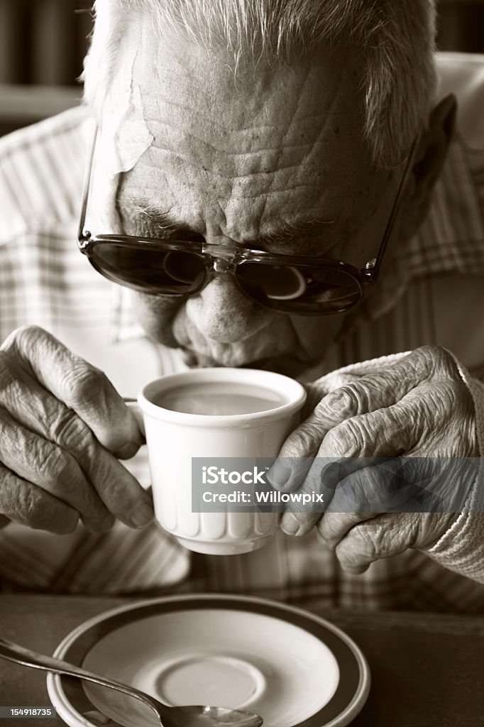 Homem sênior bebidas café com faixa de lesões e óculos de sol - Foto de stock de Adulto royalty-free