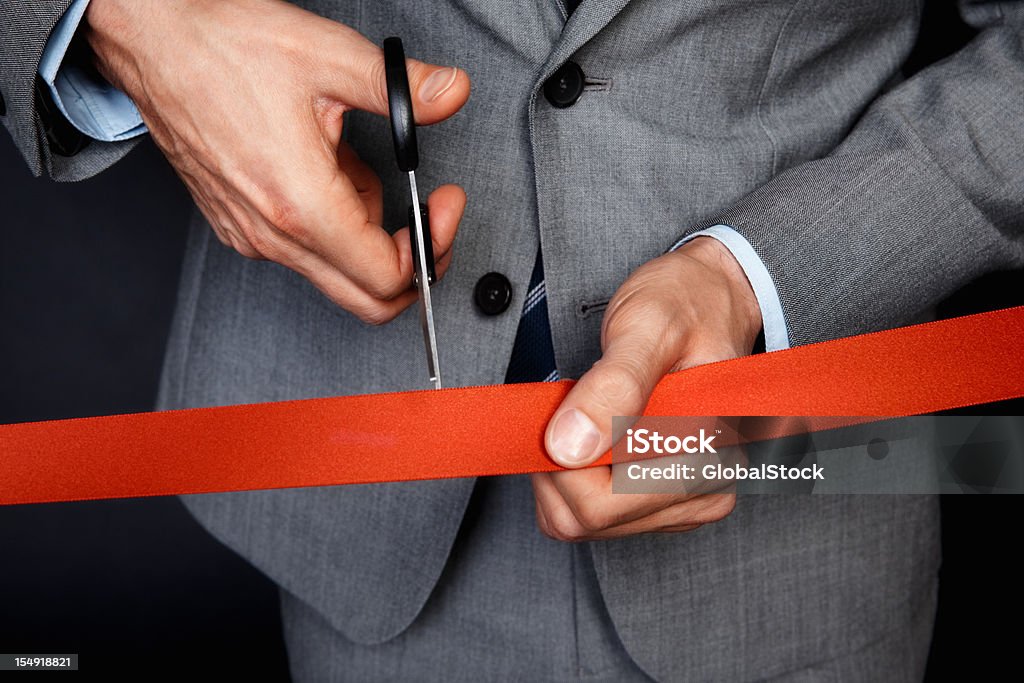 Businessman cutting ribbon Closeup of man cutting ribbon Administrator Stock Photo