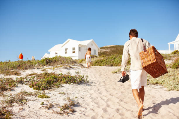 Beach picnic Rear view of father and son heading back to the cottage cottage life stock pictures, royalty-free photos & images