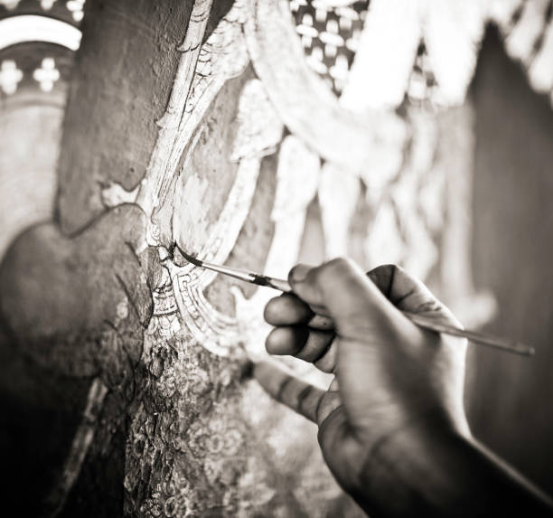 Artist Restoring a Painting in the Grand Palace An artist restoring a painting on the wall at the Grand Palace in Bangkok, Thailand. black and white travel travel destinations monk stock pictures, royalty-free photos & images