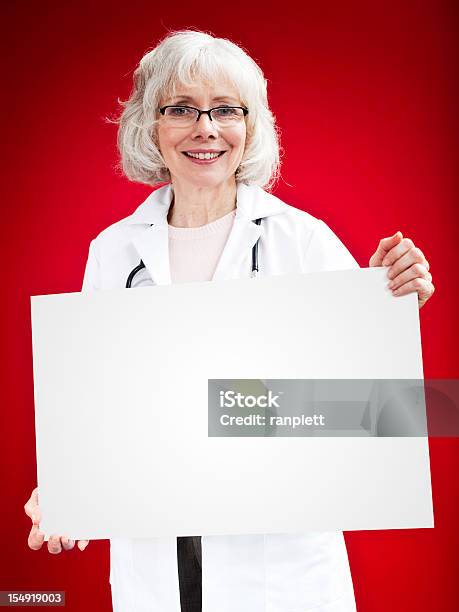シニア女性医師空の看板を保持 - 手に持つのストックフォトや画像を多数ご用意 - 手に持つ, 空白の標識, 人物