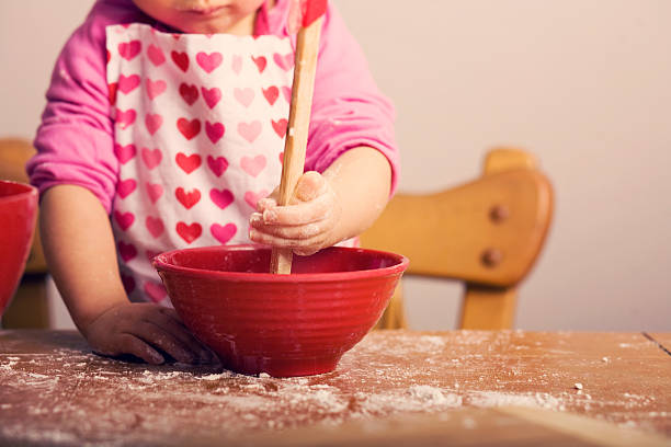Kleines Mädchen mischen Zutaten in roter Schale – Foto