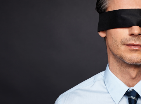 Closeup of man in shirt and tie wearing blindfold