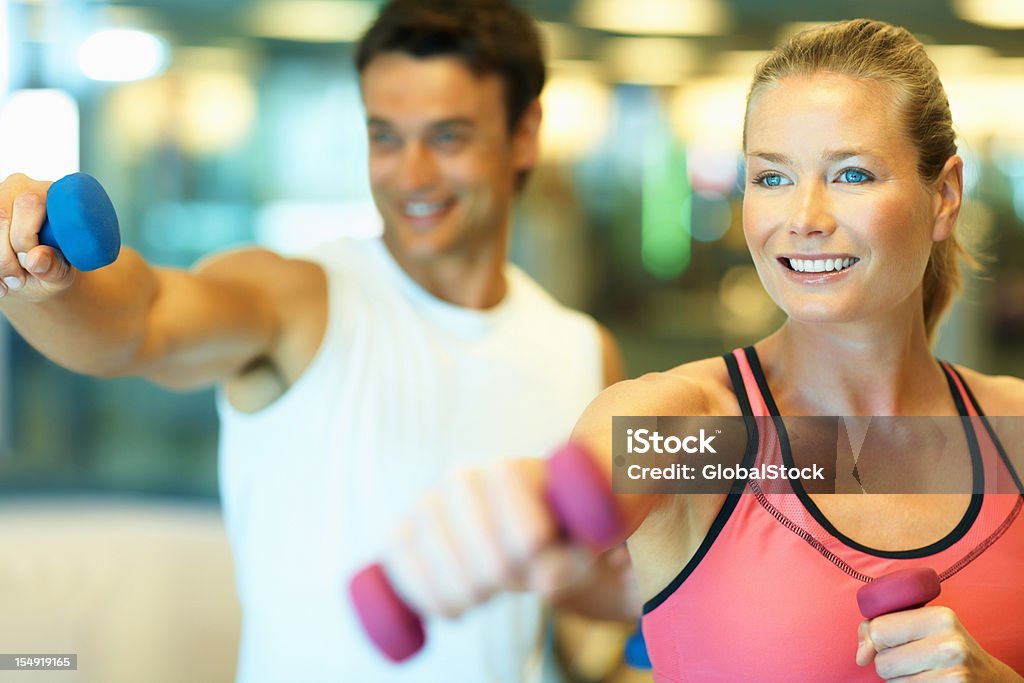 Homem e mulher fazendo exercício com halteres - Foto de stock de 20 Anos royalty-free