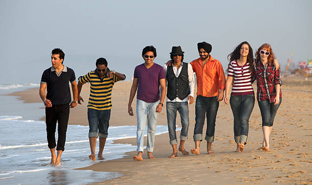 Good time on the beach in India Young people having fun on the beach in Goa, running toward the camera in shallow water on the sand. This is a diverse group of people, some Indians, some Caucasian, some mixed race. beach goa party stock pictures, royalty-free photos & images