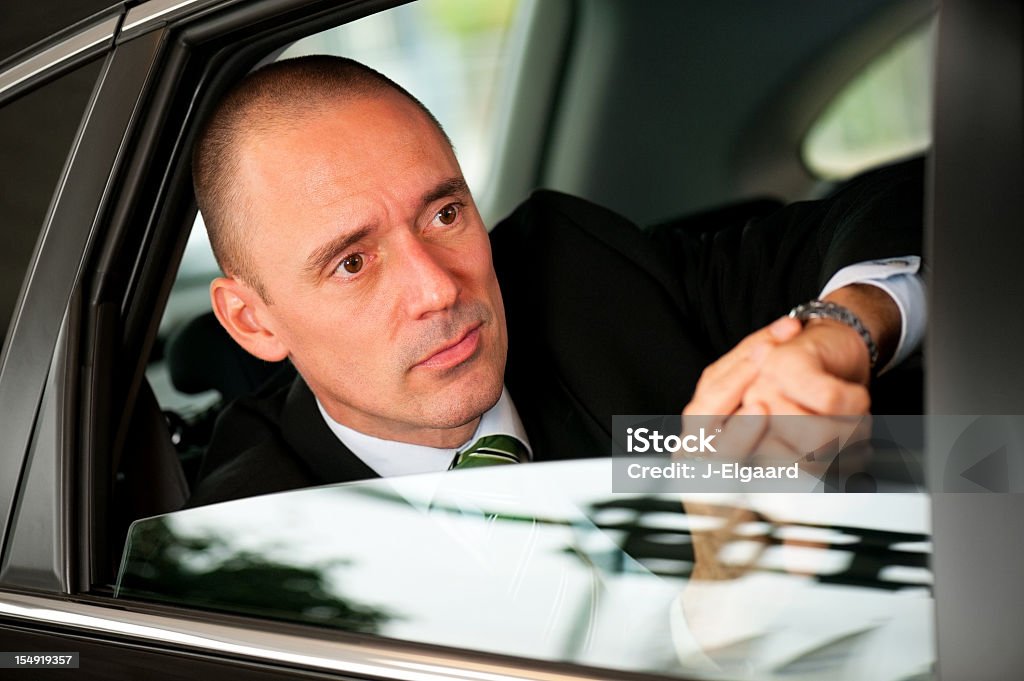 ハンサムビジネス男のチェックに時間 backseat of 車 - 1人のロイヤリティフリーストックフォト