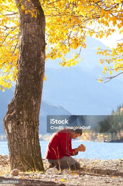 Caucasico Uomo Di Pregare Di Fianco A Un Bellissimo Lago Di Montagna - Fotografie stock e altre immagini di Divinità