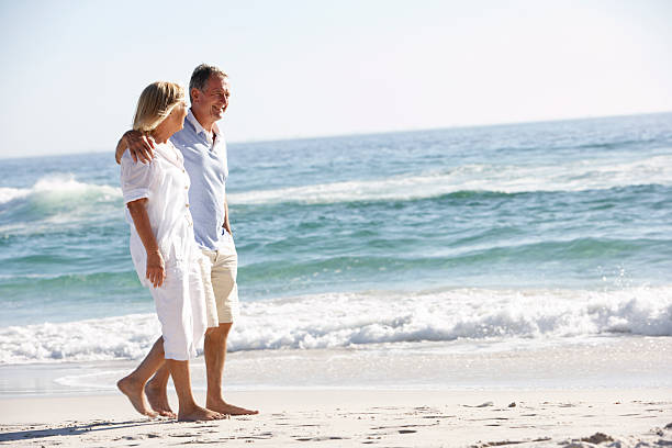 istock Senior Couple On Holiday Walking Along Beach 154919472