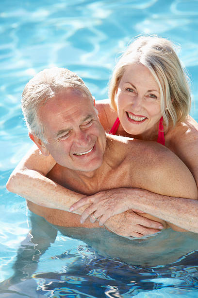 istock Senior Couple Relaxing In Swimming Pool Together 154919476