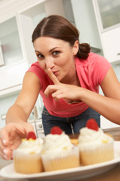 istock Woman Eating Cakes In Kitchen 154919504