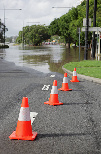 Road cones and flood Bright coloured road cones stopping traffic from flood waters, Brisbane Australia.  Depth of field with focal point on second cone. Please see my other Brisbane Flood Photos...  queensland floods stock pictures, royalty-free photos & images