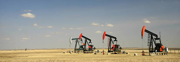 panorama d'affilée des quatre pumpjacks sur great plains - red deer, alberta photos et images de collection