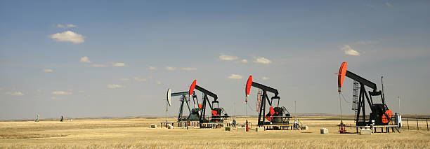 панорама ряд из четырех pumpjacks на великие равнины - oil pump oil industry alberta equipment стоковые фото и изображения