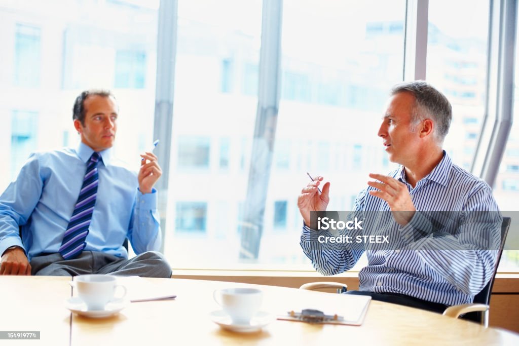 Geschäftsleute, die ein Gespräch bei Tisch - Lizenzfrei Abmachung Stock-Foto