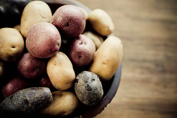 Baby potatoes in a rustic wooden bowl.