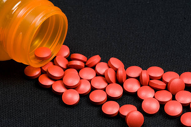 pastillas derramando de botella - hormone therapy hrt pill medicine fotografías e imágenes de stock