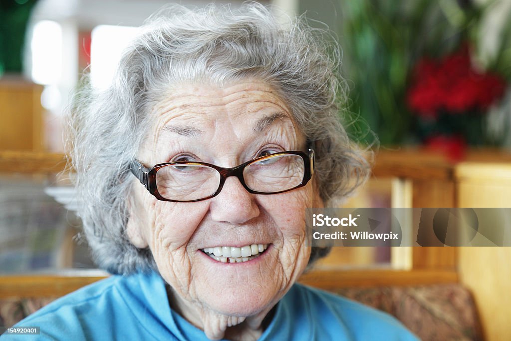 Donna anziana divertente sorridendo e guardando in faccia - Foto stock royalty-free di Terza età