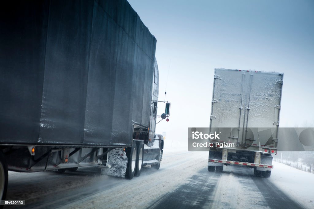 Snow storm on the highway Transport trucks roll down the freeway blizzard and slippery frozen road driving conditions Blizzard Stock Photo