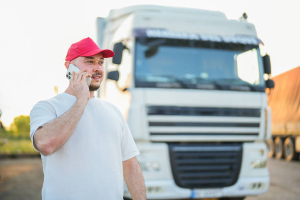homem falando ao celular na frente do caminhão - semi truck driver pride white - fotografias e filmes do acervo