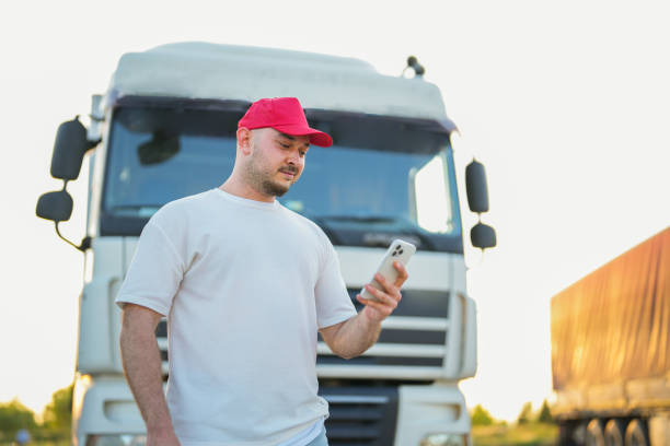 homem segurando celular na frente do caminhão - semi truck driver pride white - fotografias e filmes do acervo