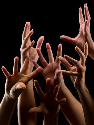 Female hands reaching out on black background