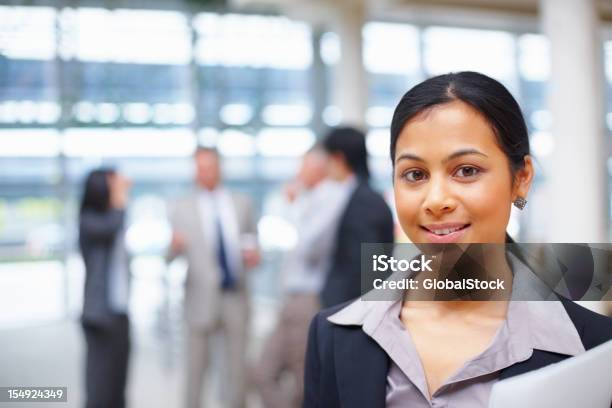 Mujer De Negocios Con Equipo De Fondo Foto de stock y más banco de imágenes de Administrador - Administrador, Oficio con título, Adulto joven