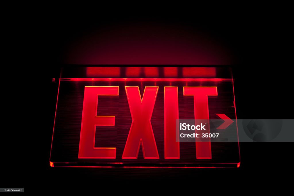 A red Illuminated exit sign on black illuminated exit sign. Exit Sign Stock Photo