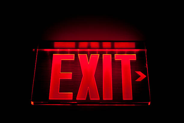 A red Illuminated exit sign on black illuminated exit sign. exit sign photos stock pictures, royalty-free photos & images
