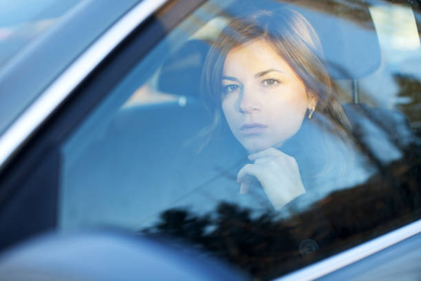 istock Beautiful woman is looking at the camera through car window. 154924472