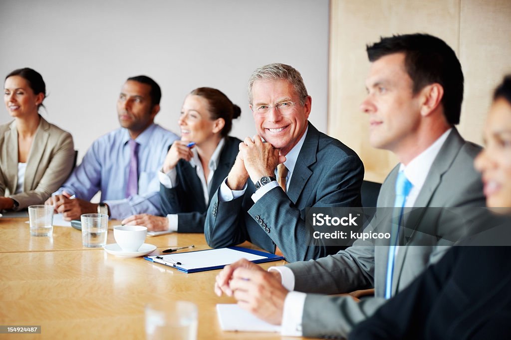 Sorridente Empresário sênior com sua equipe em uma reunião - Foto de stock de Inteligência royalty-free