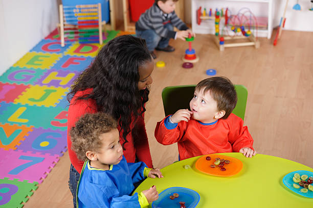 istock Pair Of Toddlers Enjoying A Meal While Their Peer Plays 154924638