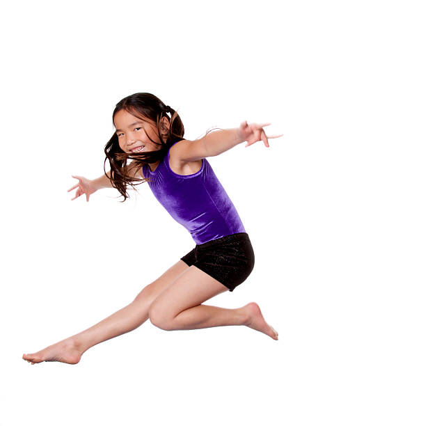 Young, Asian gymnast on a white background.  Some motion blur visible.