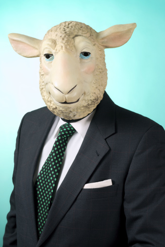 Portrait of a businessman wearing a sheep mask. Blue background with highlight.