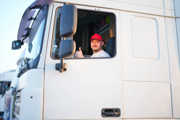 homem do motorista no boné vermelho sentado no assento do caminhão branco - semi truck driver pride white - fotografias e filmes do acervo