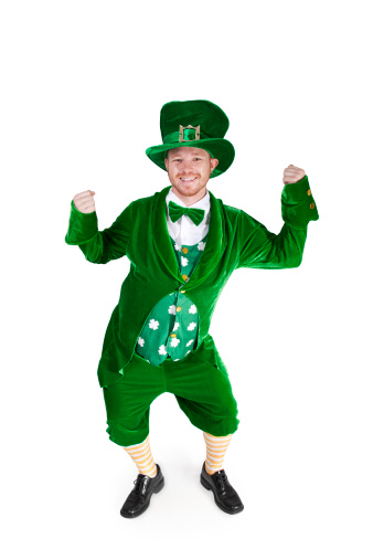 Full length photograph of an adult man in a leprechaun suit dancing; copy space 