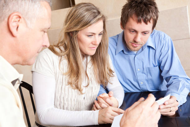 istock Adult Couple Looking at Document With Older Advisor 154925424